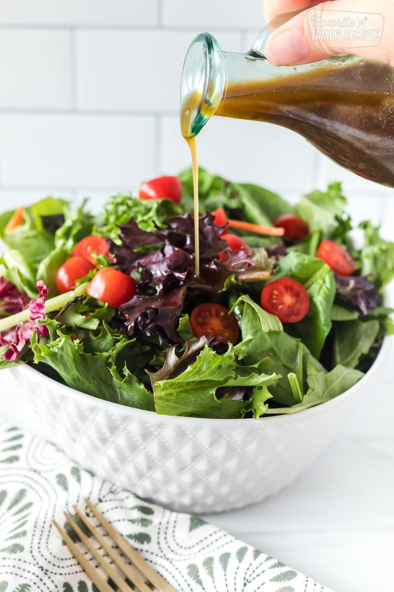 This is the simplest and best balsamic vinaigrette dressing. It only requires a few basic ingredients and takes less than ten minutes to make! Balsamic vinaigrette being poured over a green salad.