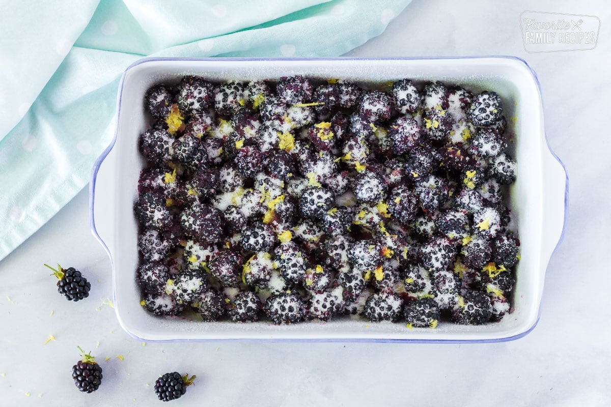 Baking dish with fresh blackberries, lemon zest and sugar to make Easy Blackberry Cobbler.