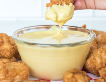 A chicken nugget slowly being dipped into homemade chick-fil-a sauce recipe