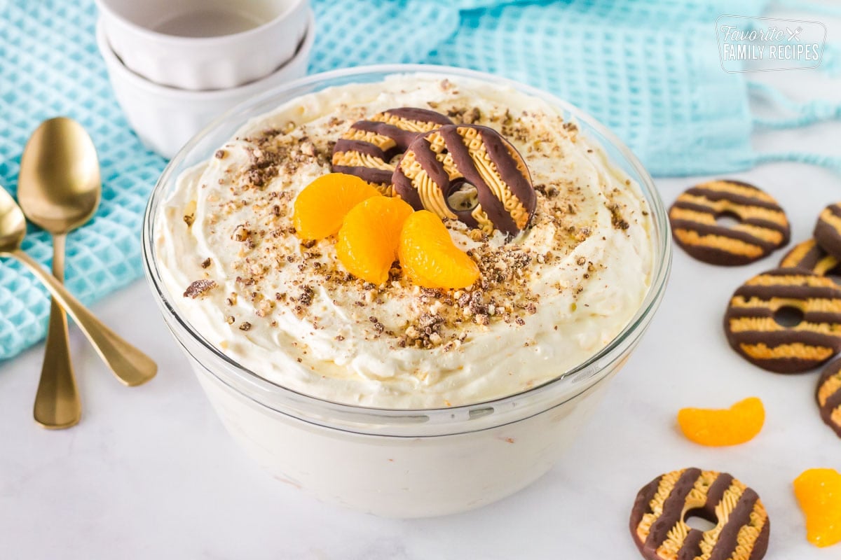 Bowl of Cookie Salad with fudge stipe cookies and mandarin oranges. Bowls and spoons on the side.