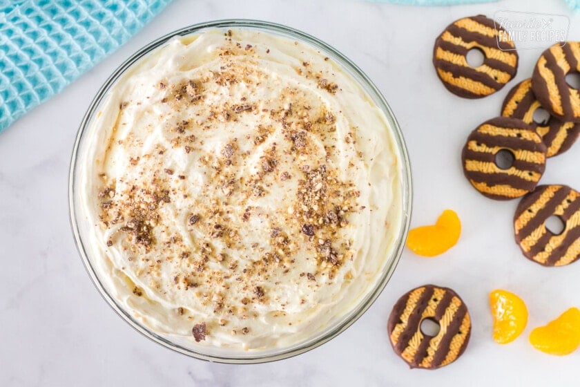 Bowl of Cookie Salad mix with Fudge stripe cookie crumbs mixed in. Fudge striped cookies and mandarin oranges on the side.
