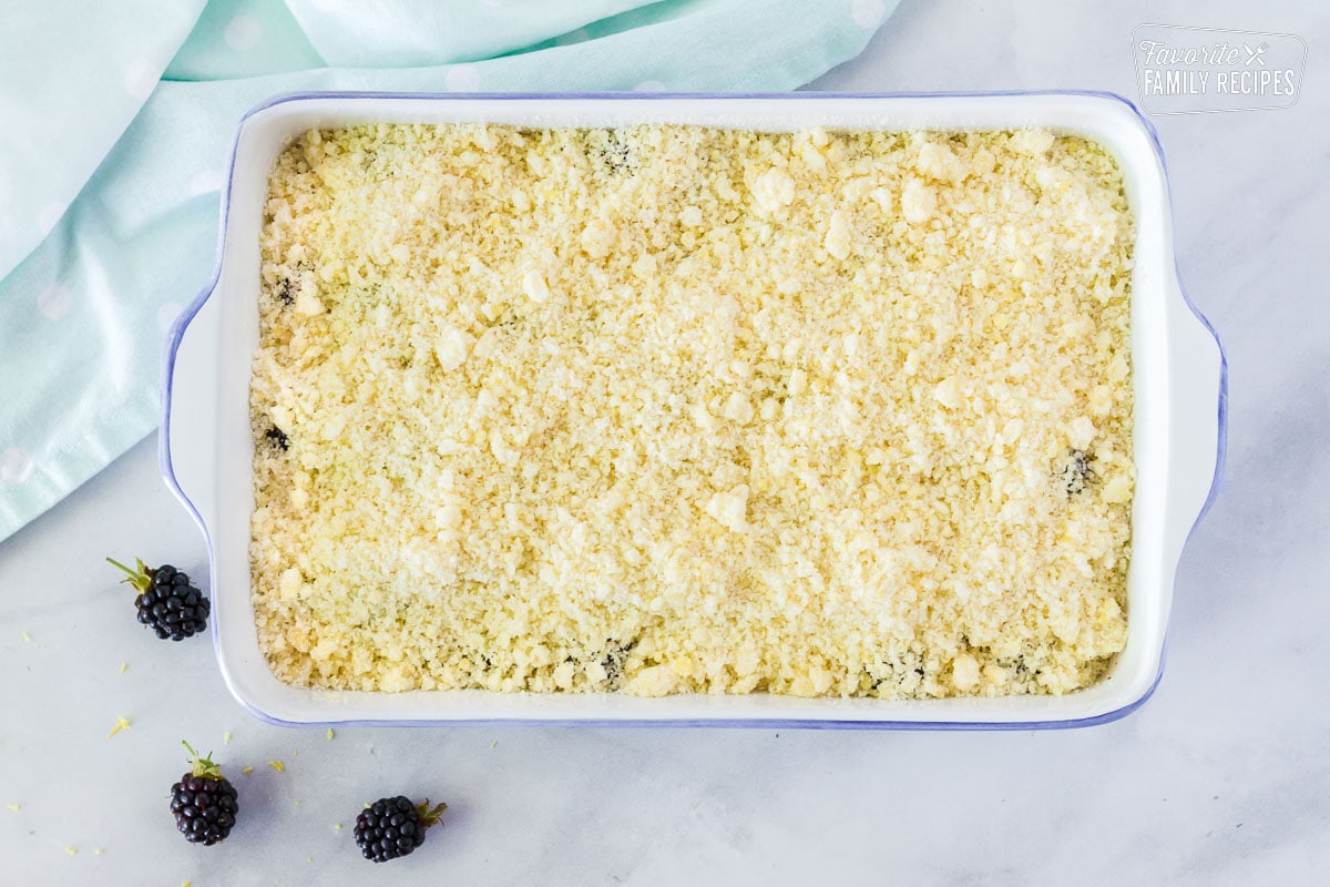 Pan with crumble topping covering the fresh blackberries to make Easy Blackberry Cobbler.