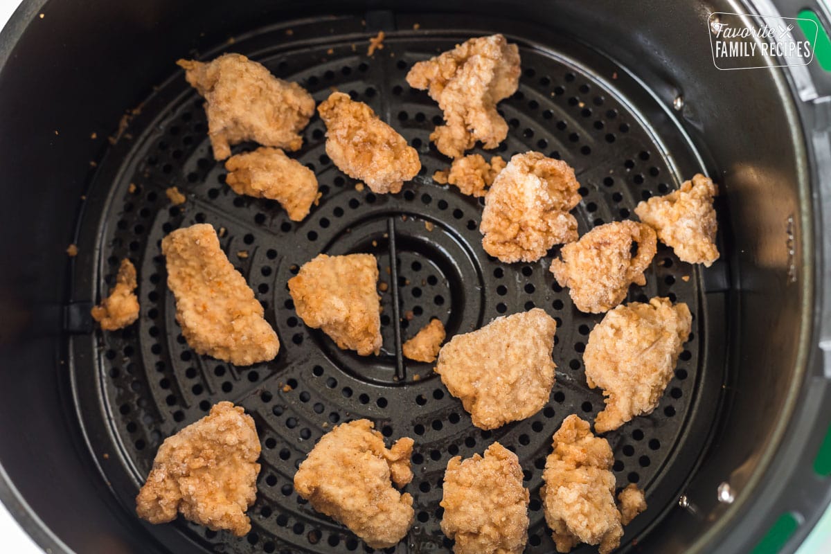 Frozen chicken nuggets in an air fryer basket