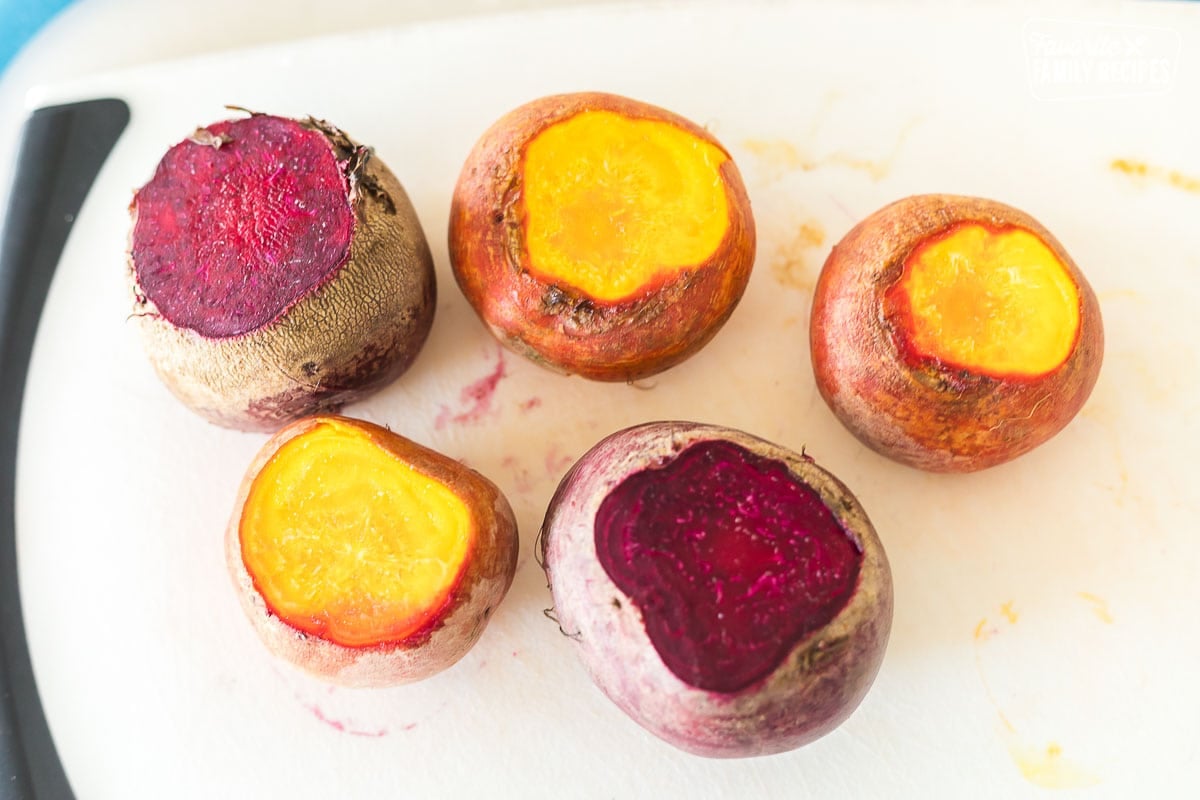 Learn the easiest way to oven roast beets and discover new ways of serving them! Our step-by-step guide will teach you everything you need to know about roasted beets. Red and golden beets on a cutting board with the tops cut off.
