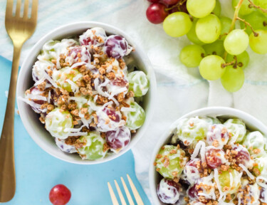 Top view of two bowls of Grape Salad with fresh grapes.