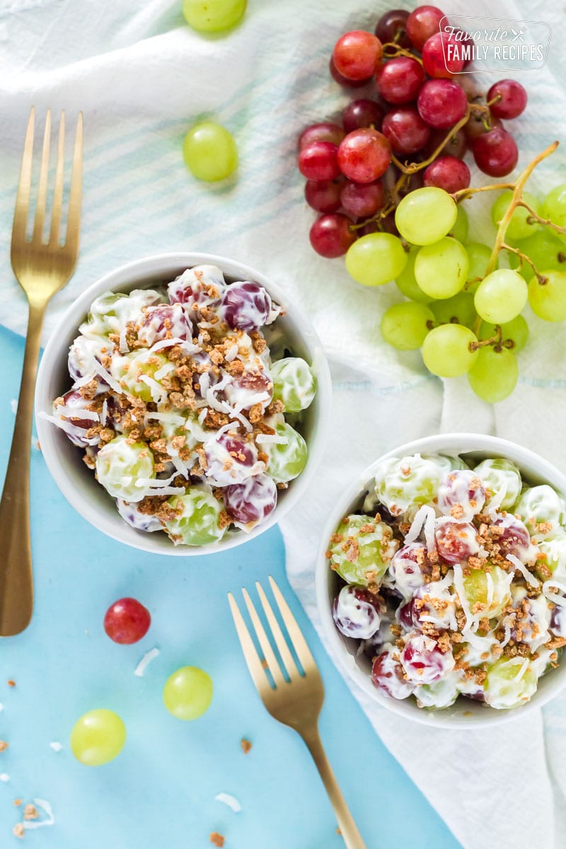 Top view of two bowls of Grape Salad with fresh grapes.