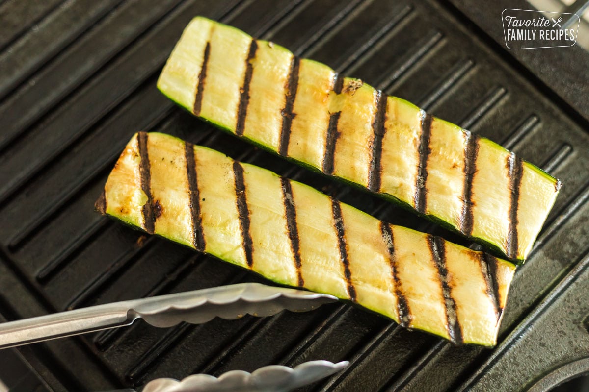 Grilled zucchini halves on a grill plate.