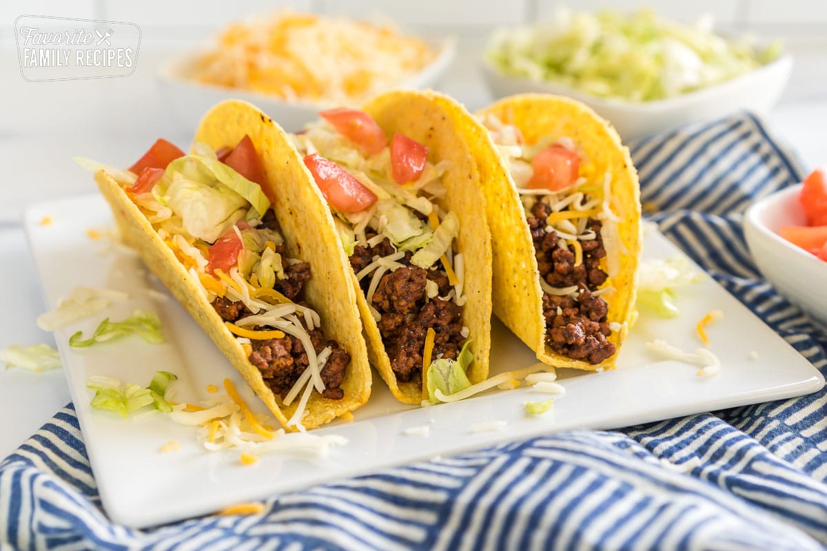 Tacos lined up with fillings on a white platter. 