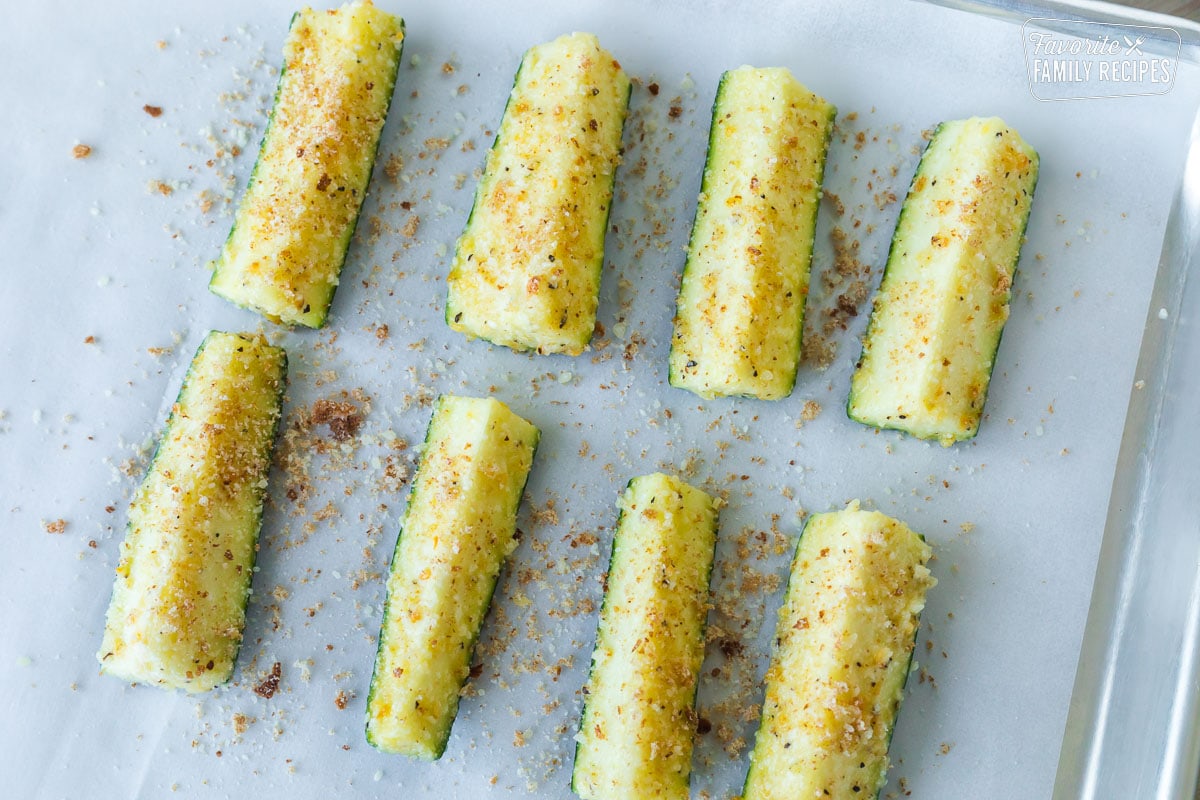 Seasoned zucchini spears on a roasting pan ready to be roasted