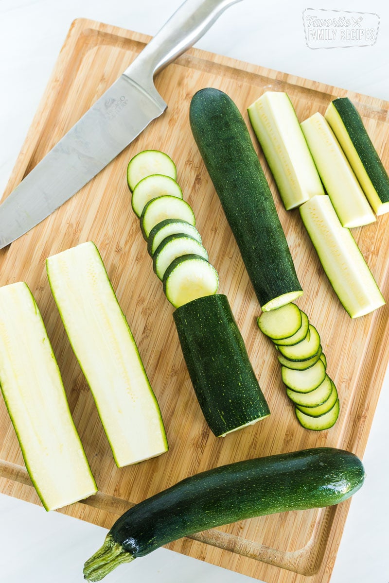 Zucchini on a cutting board sliced in different ways.