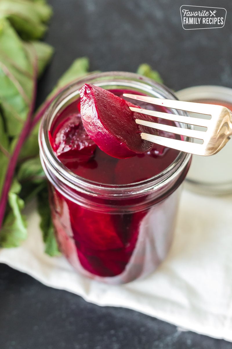 A fork holding a sliced, pickled beet