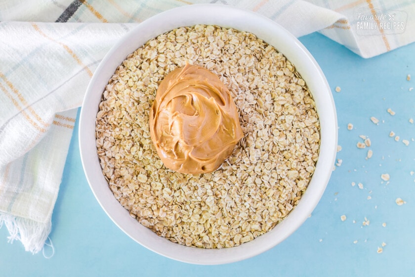 Bowl of oatmeal, peanut butter and vanilla to make No Bake Cookies.