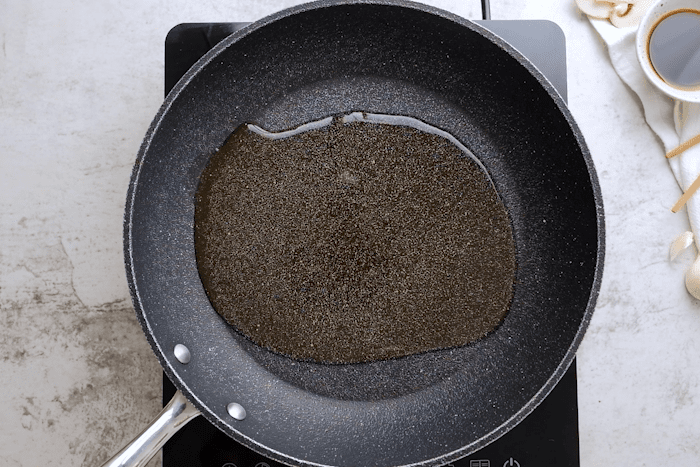 Olive oil heating up in a pan for Panda Express Mushroom Chicken.