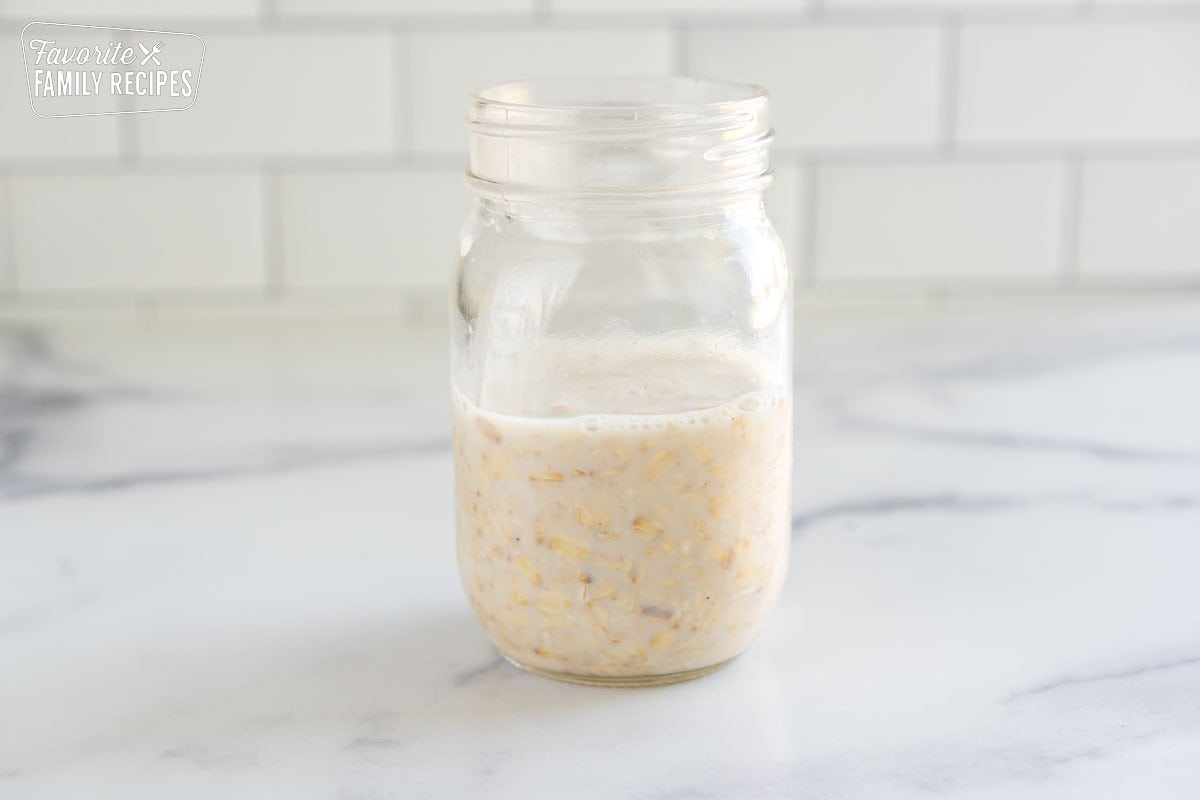 A mason jar with milk and oats inside