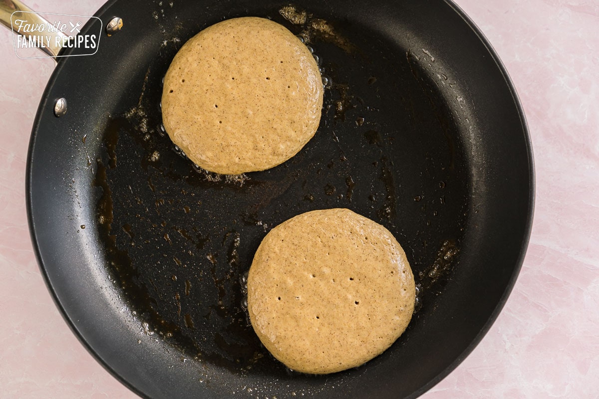 two pancakes being cooked in a skillet