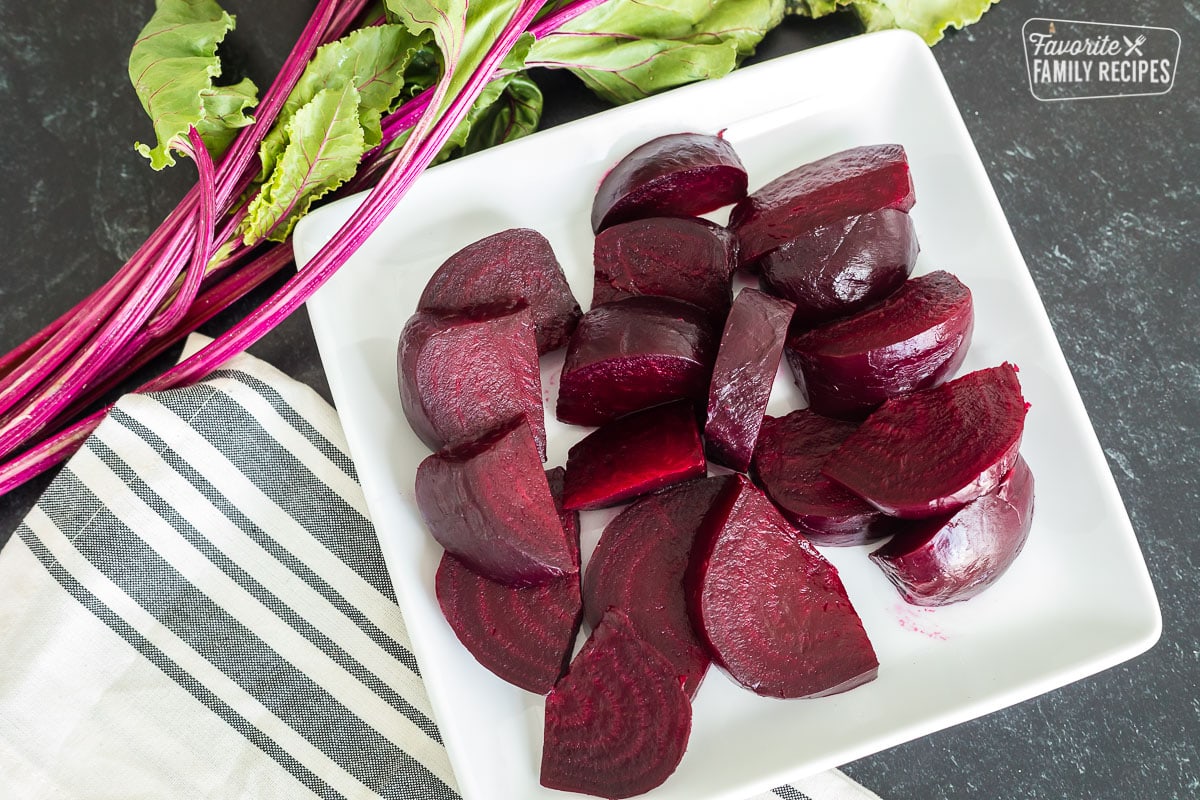Sliced roasted beets on a white plate.