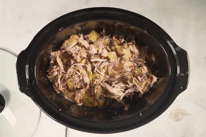 Shredded pork over cabbage in a crockpot for Crockpot Hawaiian Kalua Pork with Cabbage.