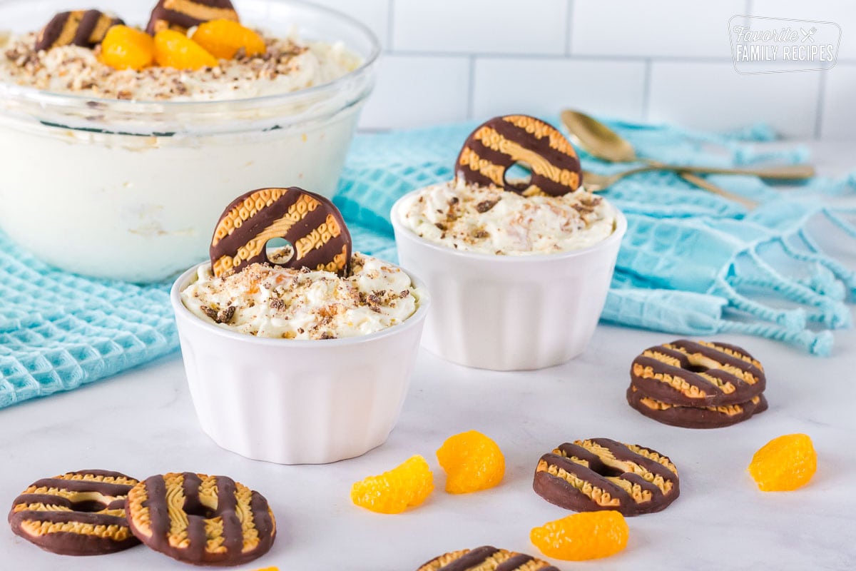 Two serving bowls of Cookie Salad garnished with a fudge stripe cookie.