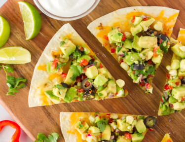 Separated slices of Avocado Quesadilla with dips.