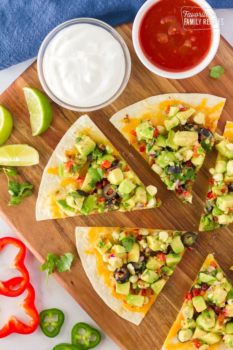 Separated slices of Avocado Quesadilla with dips.
