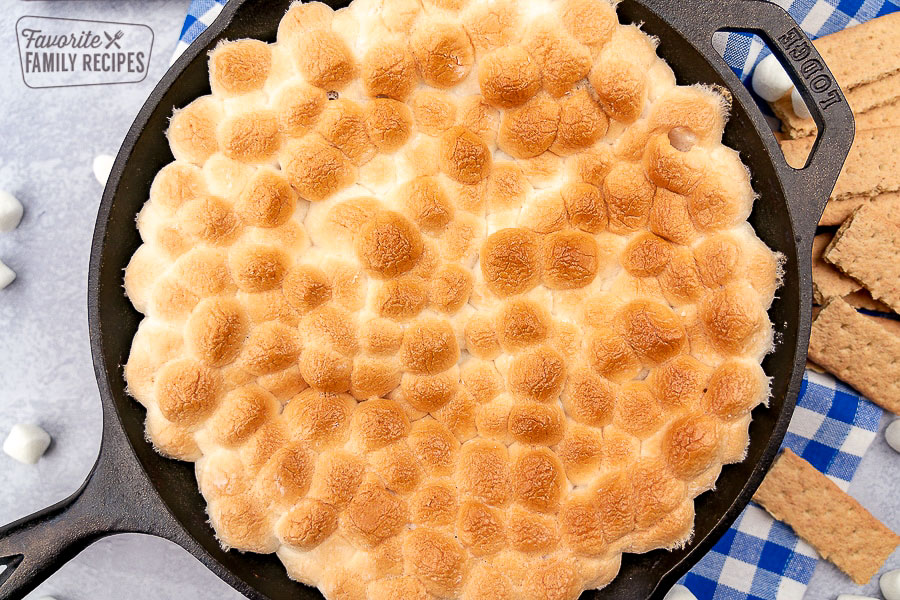 smores dip with toasted marshmallows in a cast iron skillet