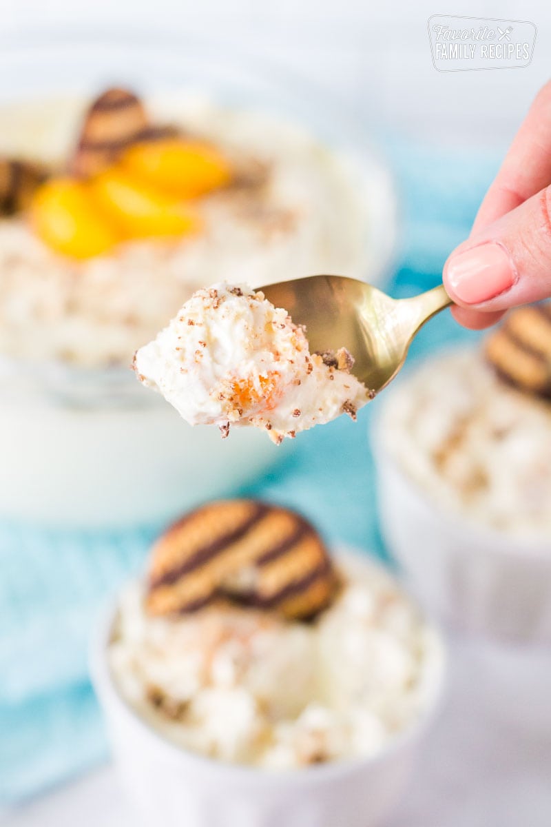 Close up of spoonful of Cookie Salad with fudge stripe cookies and mandarin oranges.