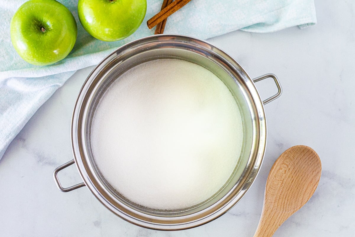 Heavy pan with sugar and a wooden spoon to make the Salted Carmel topping the Apple Cheesecake Bars.