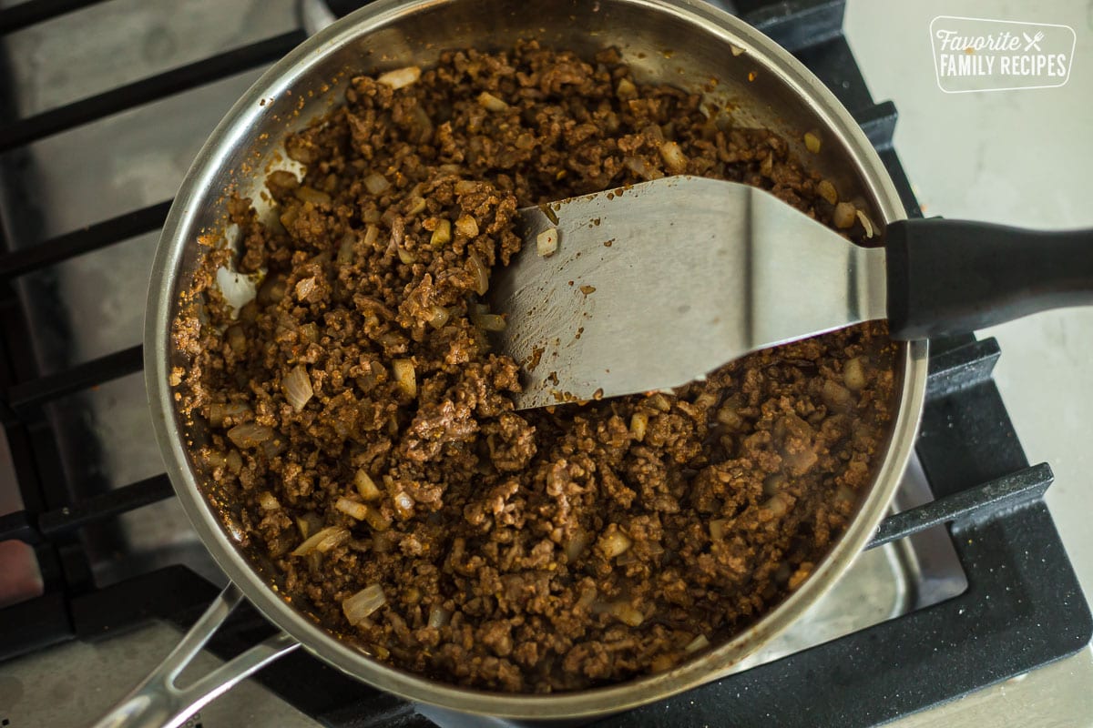 Cooked ground beef and onions in a skillet