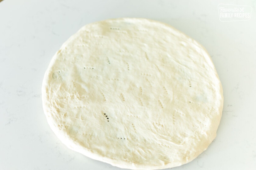 Pizza dough stretched onto a pizza stone