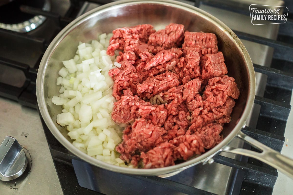 ground beef and raw onions in a frying pan