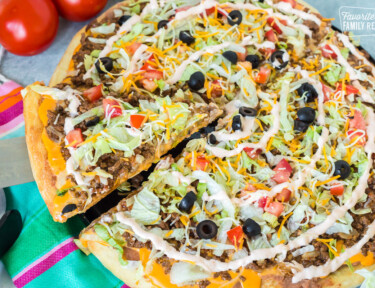 A slice being taken from a taco pizza
