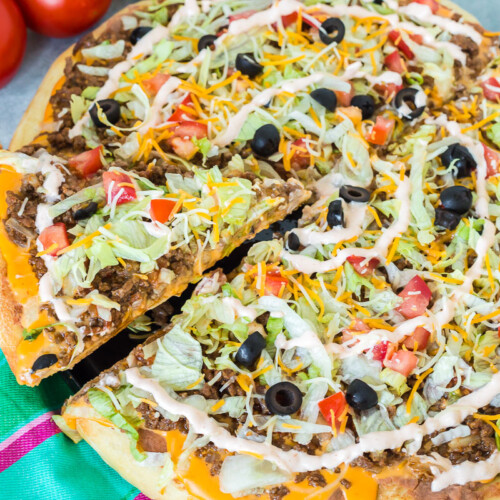 A slice being taken from a taco pizza