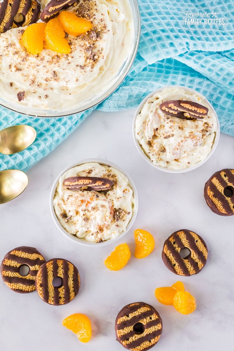 Top view of two small bowls with Cookie Salad. Garnished with fudge stripe cookies and mandarin oranges.