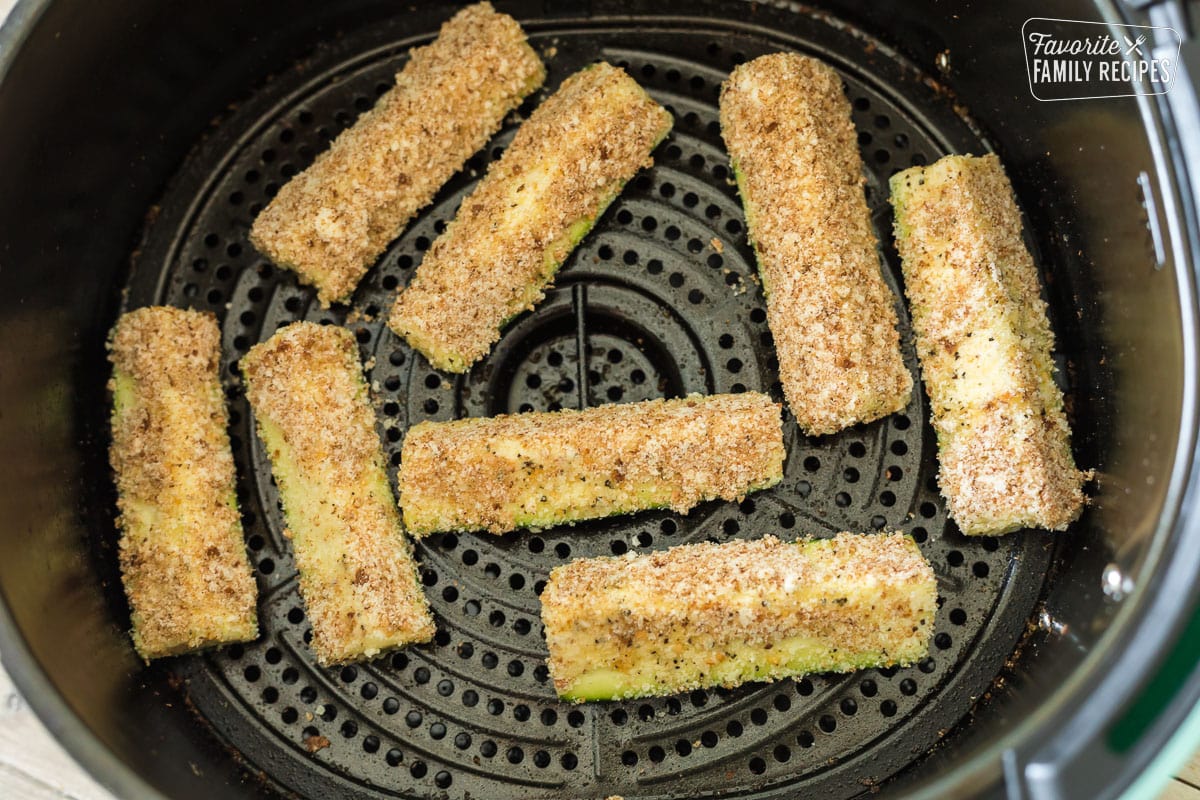 Breaded zucchini spears in an air fryer basket