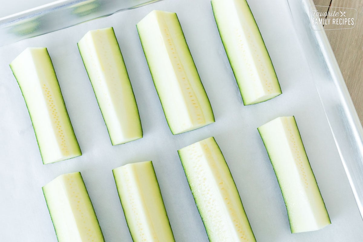 Cut zucchini spears on a roasting pan.