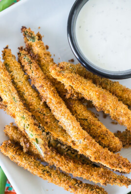 Air fryer green bean fries next to a cup of ranch dressing