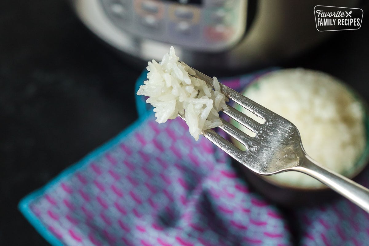 A fork holding a bite of Instant Pot rice.