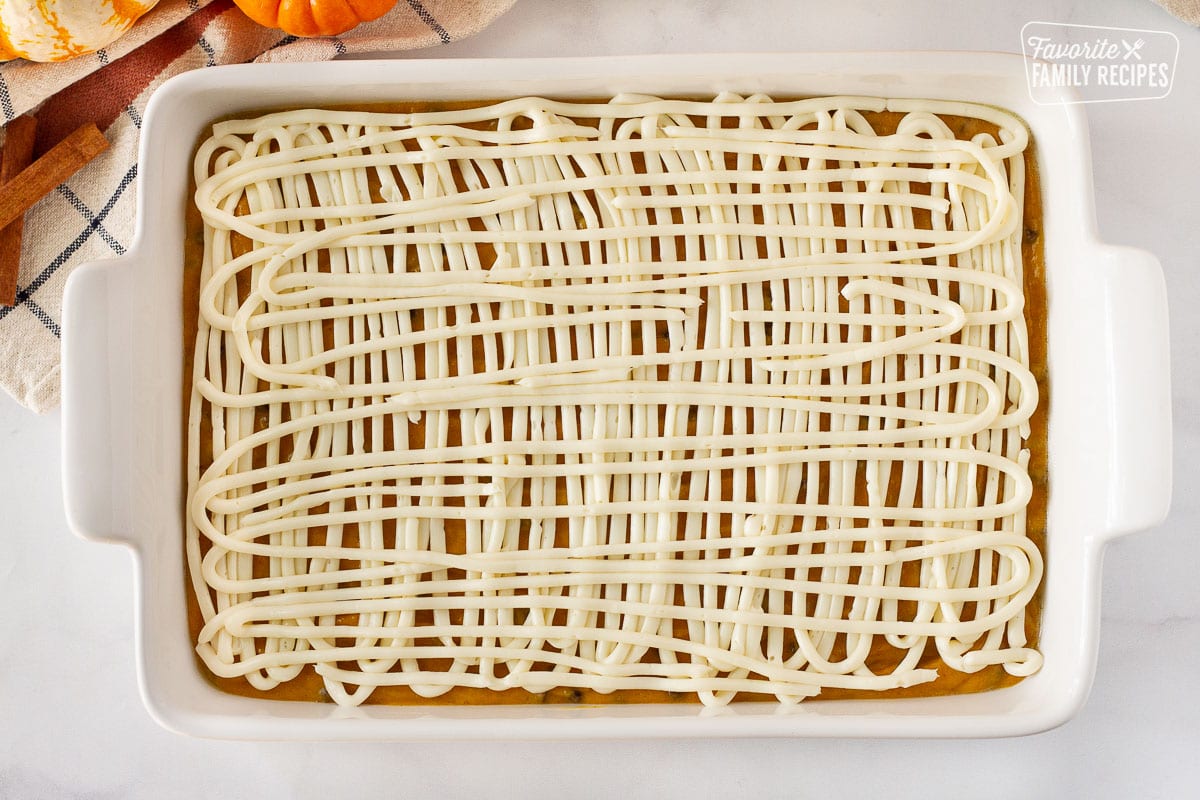 Baking dish with the cheesecake mixture swirled on top of the Pumpkin Coffee Cake batter.