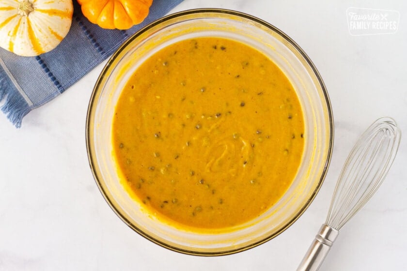 Bowl of Pumpkin Sheet Cake with mini chocolate chips. Whisk on the side.