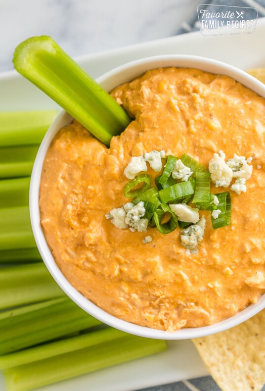 Buffalo chicken dip in a bowl with celery dipped in it