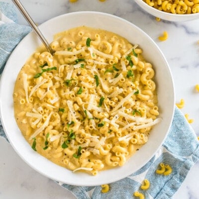 A bowl of mac and cheese topped with parsley and cheese
