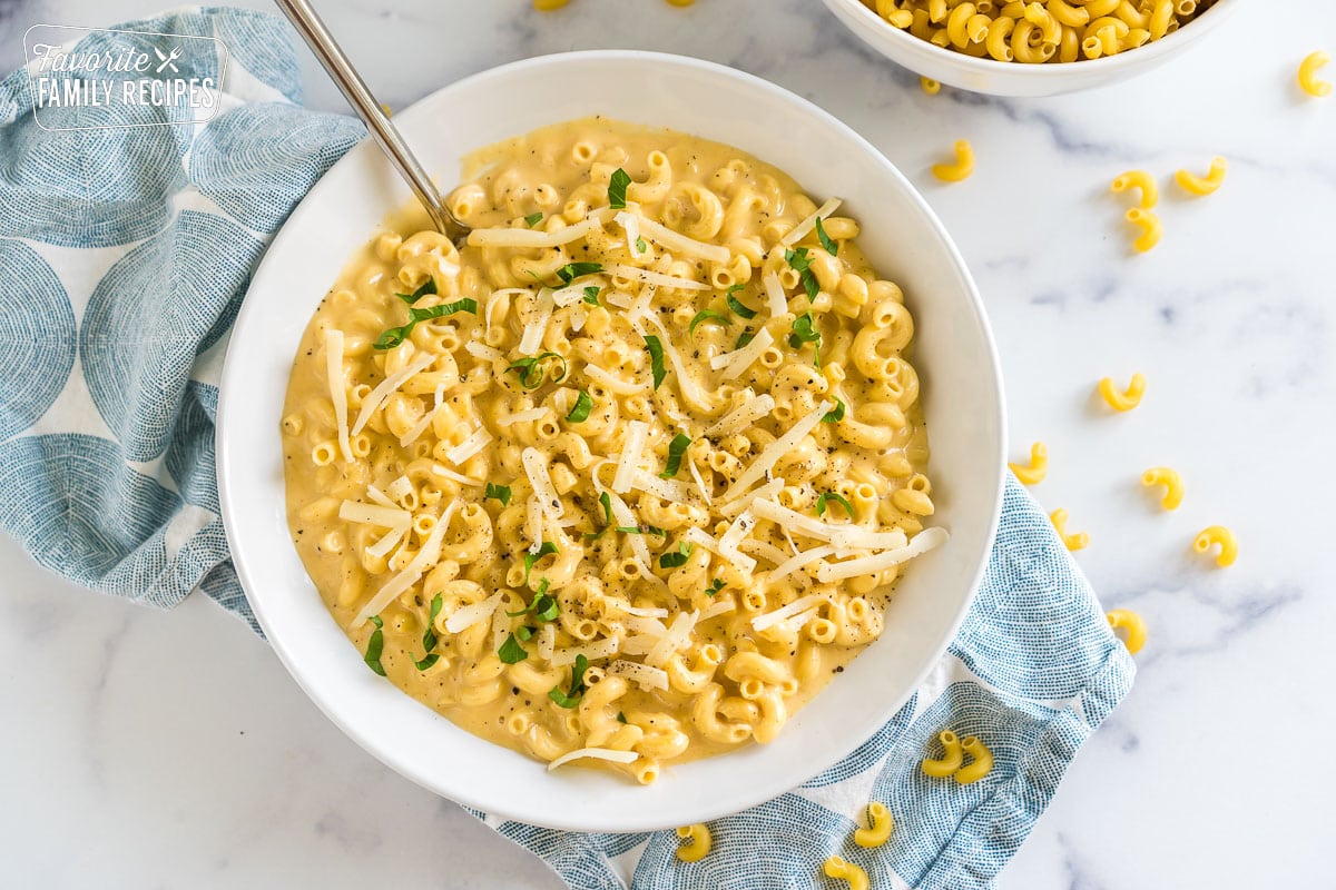 A bowl of mac and cheese topped with parsley and cheese.
