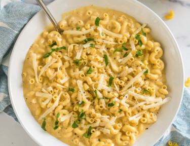 A bowl of mac and cheese topped with parsley and cheese
