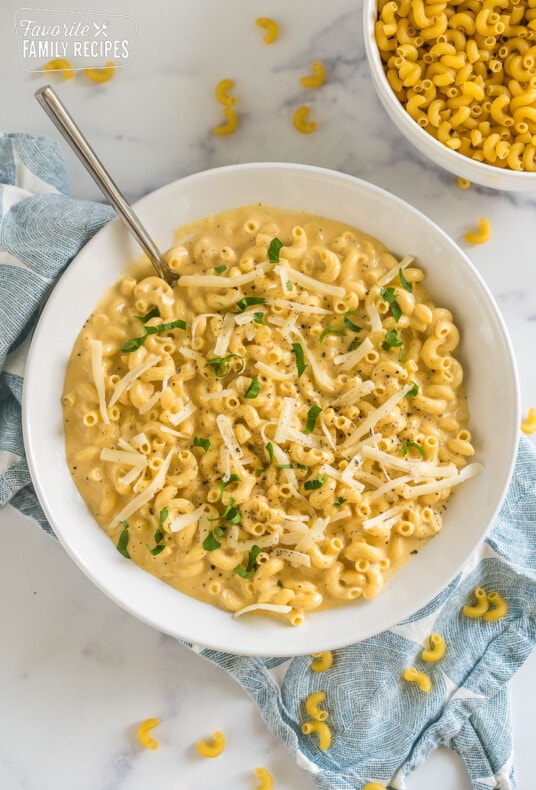 A bowl of mac and cheese topped with parsley and cheese