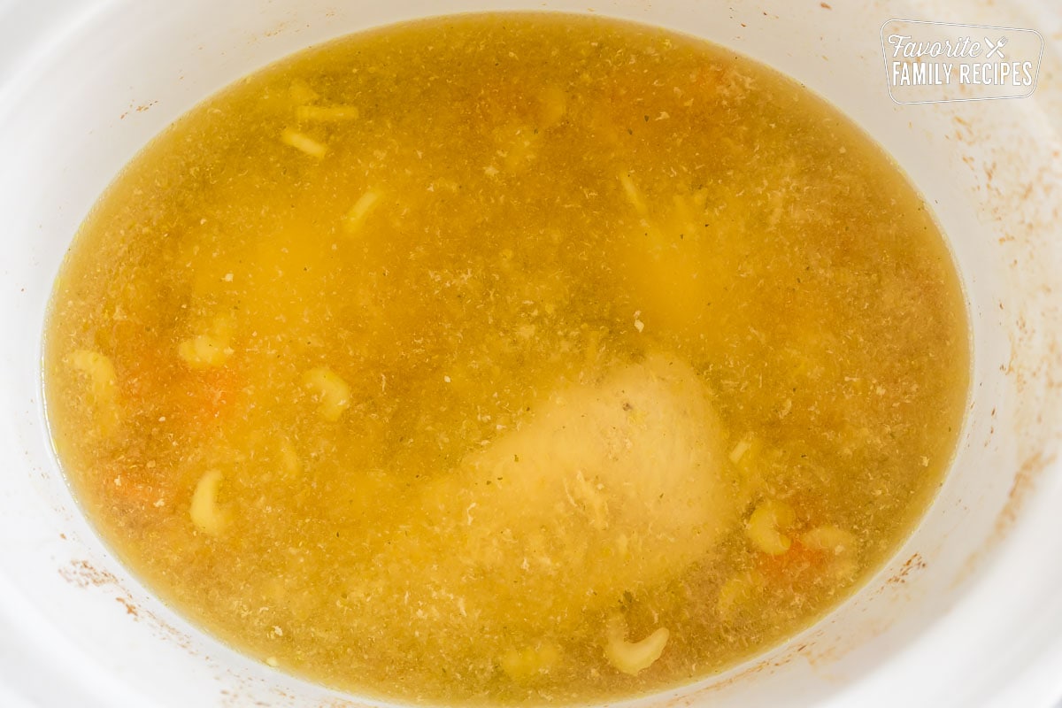 Chicken and vegetables cooking in chicken broth in the crockpot