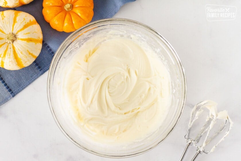 Bowl of Pumpkin Sheet Cake frosting. Mixing beaters on the side.