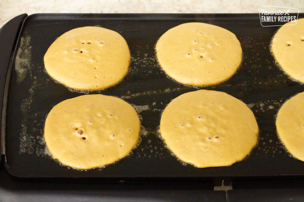 Circle Whole Wheat Pancakes cooking on the griddle.