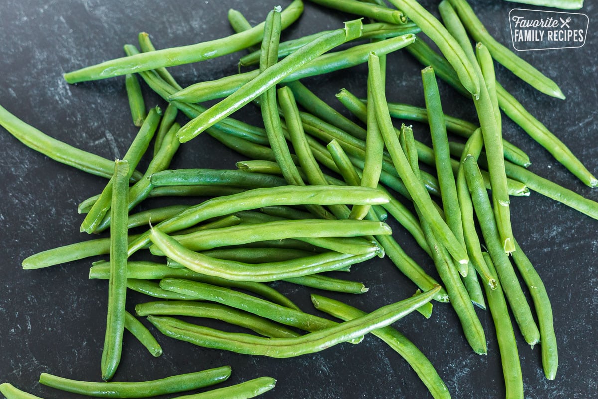 Fresh green beans on a black surface