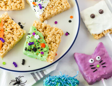 Halloween Rice Krispie treats in the shape of a pumpkin, ghost, cat, and Frankenstein