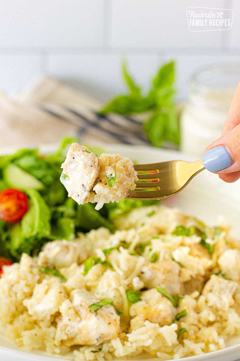 Fork holding a bite of Instant Pot Chicken and Rice.